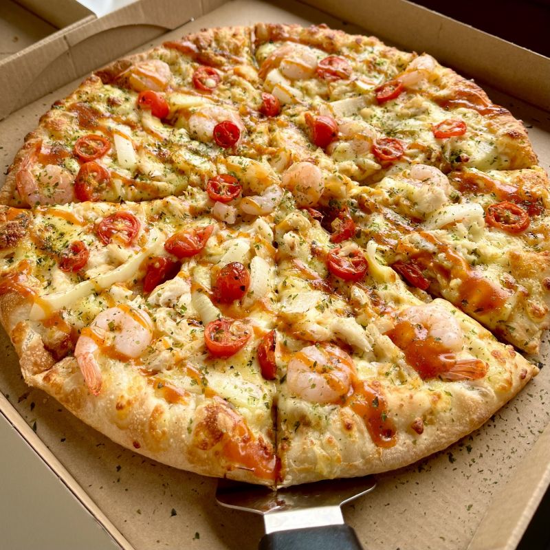 Pizza hải sản nhiệt đới sốt tiêu là nơi sự tươi ngon của hải sản và hương vị độc đáo của sốt tiêu kết hợp một cách hoàn hảo. Mỗi miếng pizza phủ đầy các loại hải sản như tôm, mực với lớp sốt tiêu cay nồng, tạo nên một trải nghiệm ẩm thực phong phú và đầy ấn tượng