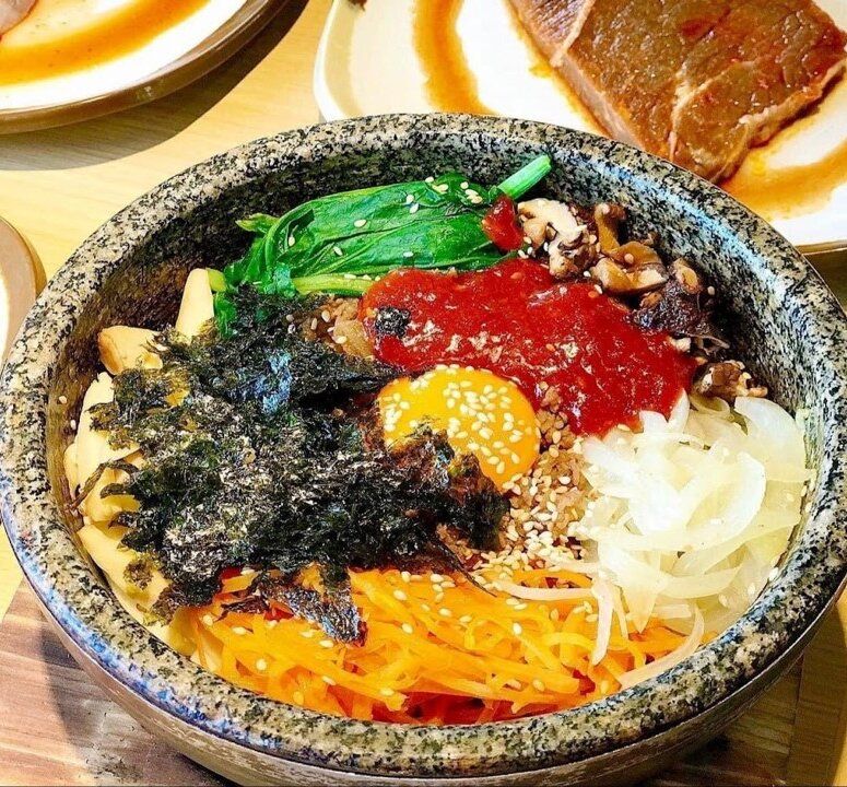 Cơm trộn Hàn Quốc (Bibimbap) là một món ăn kết hợp độc đáo giữa cơm và một loạt các nguyên liệu tươi ngon. Với sự hòa quyện của rau củ như cà rốt, rau, nấm, cùng với thịt bò, trứng, cùng nước sốt đã tạo nên một món ăn vô cùng hấp dẫn
