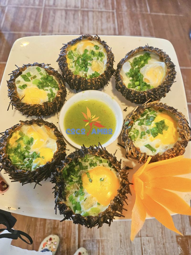 Món nhum nướng phô mai tại Coco Jambo Quy Nhơn là sự kết hợp độc đáo giữa vị béo ngậy của phô mai mozzarella, vị mặn mòi của nhum biển và hương thơm nồng nàn của hành lá.
