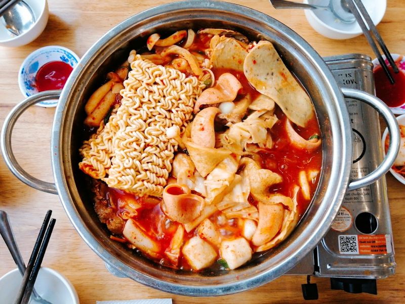 Món lẩu quân đội kết hợp giữa hương vị cay nồng của sốt gochujang với nhiều loại thực phẩm khác nhau. Món lẩu này bao gồm thịt heo, xúc xích, mì gói, rau củ và kimchi, tạo nên một bữa ăn phong phú, đầy màu sắc và thơm ngon